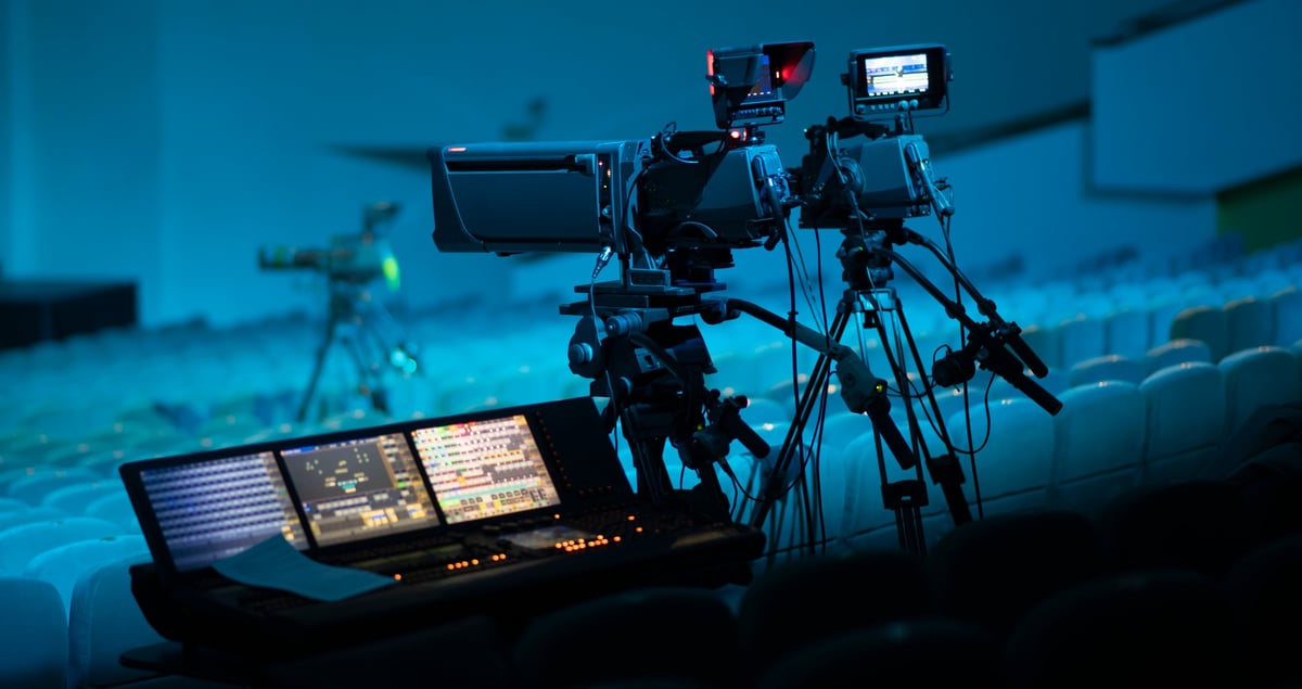High-end broadcasting equipment with digital video switcher and professional cameras in a dark studio with cinematic lighting